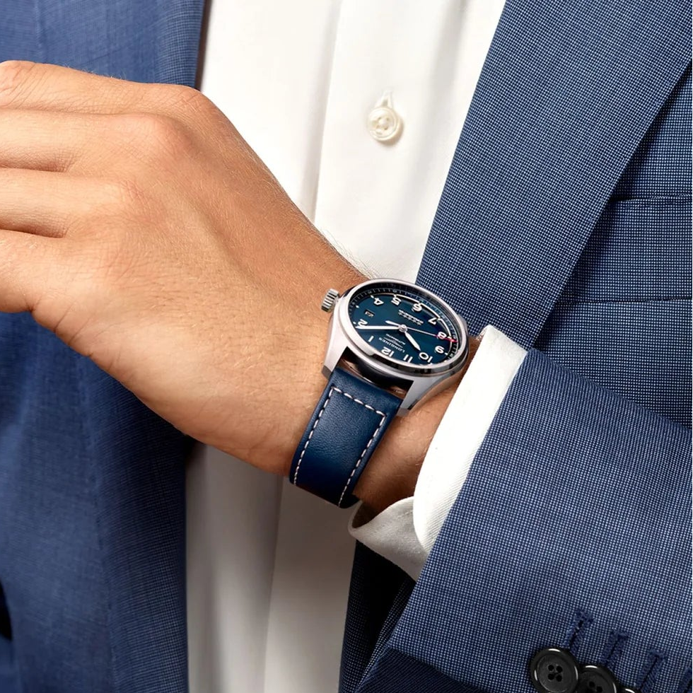 Person wearing a blue suit with a matching watch on a blurred background